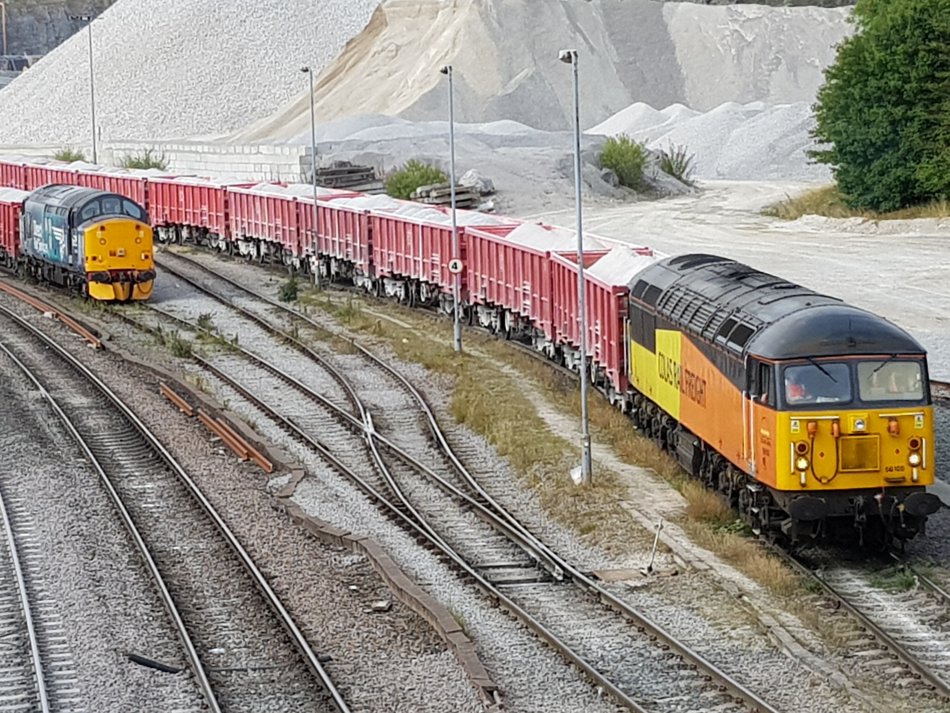 Latest Victa Rail / GBRf hire-in loco 56105 stands at Peak Forest alongside fellow hire-in 37716 on 28th July 2018. 56105 has recently replaced 56113 on such duties. Photo copyright: Keith Bulmer.